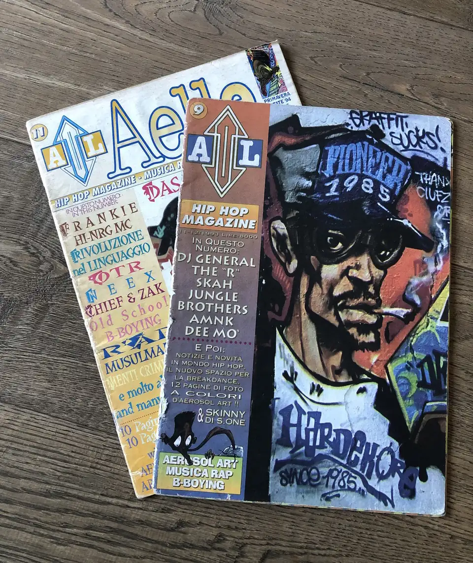 Two stacked issues of Aelle hip-hop magazine show graffiti character artwork and headlines that capture Italy’s 1990s scene.